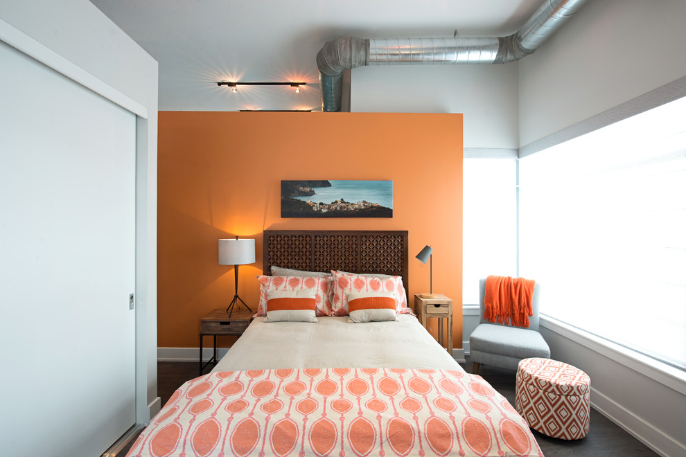 Imagen de dormitorio principal contemporáneo pequeño con parades naranjas y suelo de madera en tonos medios