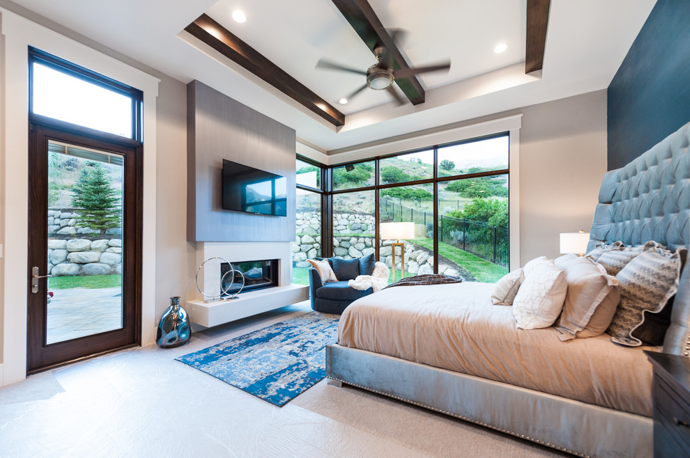 Стильный дизайн: хозяйская спальня среднего размера в стиле неоклассика (современная классика) с синими стенами, ковровым покрытием, стандартным камином и фасадом камина из бетона - последний тренд