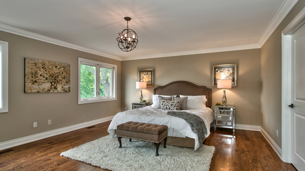 Large classic master bedroom in Toronto with medium hardwood flooring, brown walls, no fireplace and brown floors.