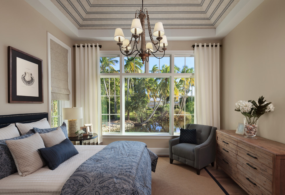 This is an example of a coastal master bedroom in Miami with beige walls and no fireplace.