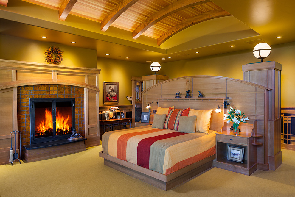 Стильный дизайн: большая хозяйская спальня в классическом стиле с зелеными стенами, ковровым покрытием, стандартным камином и фасадом камина из плитки - последний тренд