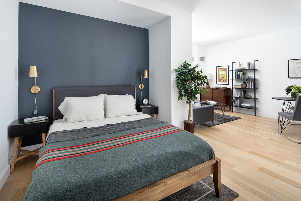 Ispirazione per una camera da letto contemporanea con pareti blu, parquet chiaro e pavimento beige