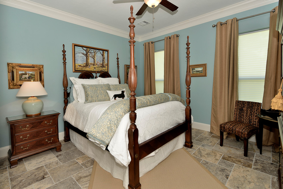 Modelo de dormitorio principal clásico de tamaño medio con paredes azules y suelo de travertino