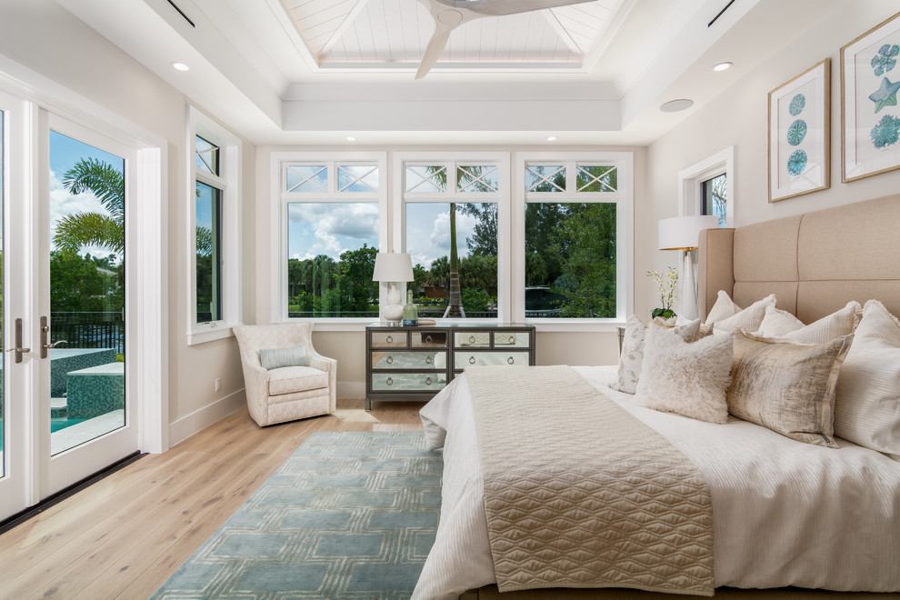 Großes Maritimes Hauptschlafzimmer mit weißer Wandfarbe, braunem Holzboden und beigem Boden in Miami