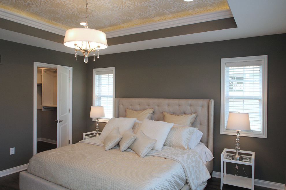 Modelo de dormitorio principal tradicional renovado de tamaño medio sin chimenea con paredes grises y suelo laminado