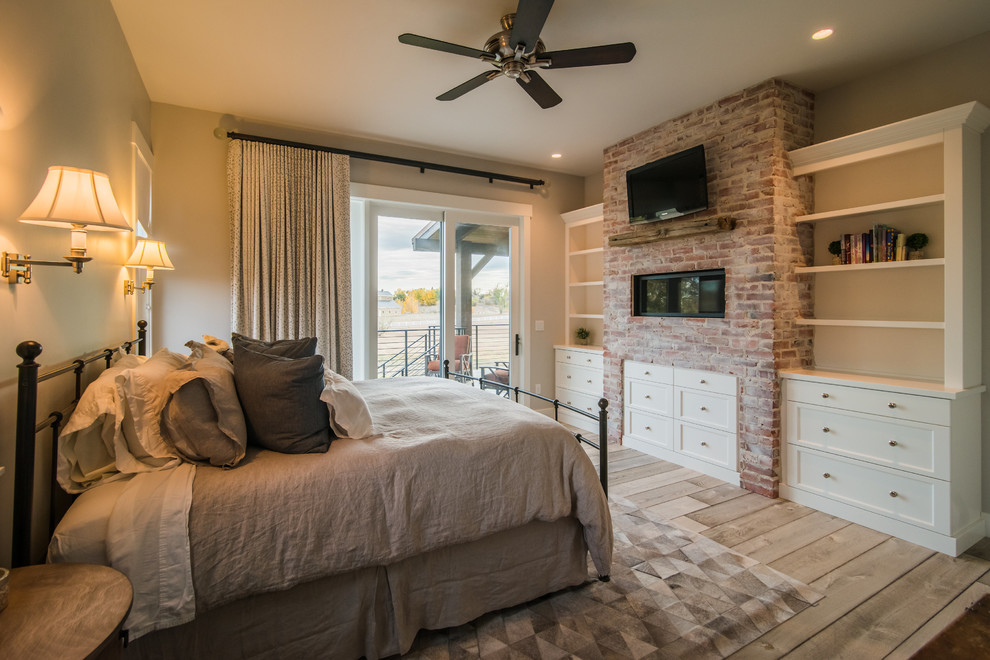Mid-sized mountain style guest light wood floor and beige floor bedroom photo in Denver with gray walls, a ribbon fireplace and a brick fireplace