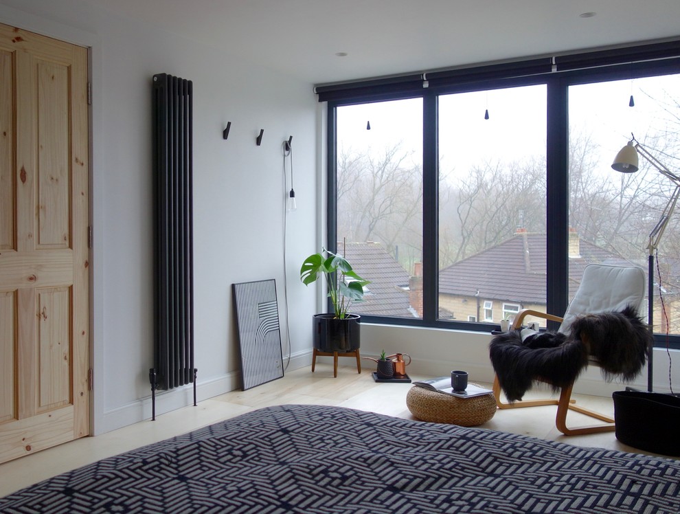 Idéer för att renovera ett mellanstort minimalistiskt gästrum, med vita väggar och plywoodgolv