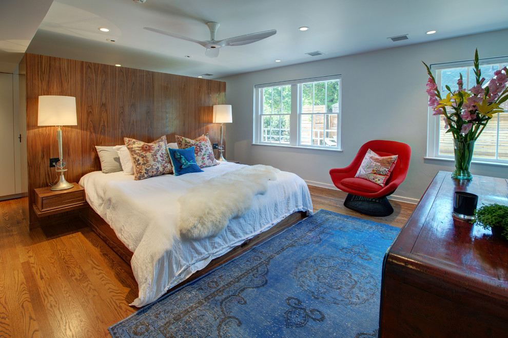 Modelo de dormitorio principal contemporáneo de tamaño medio con paredes blancas y suelo de madera en tonos medios