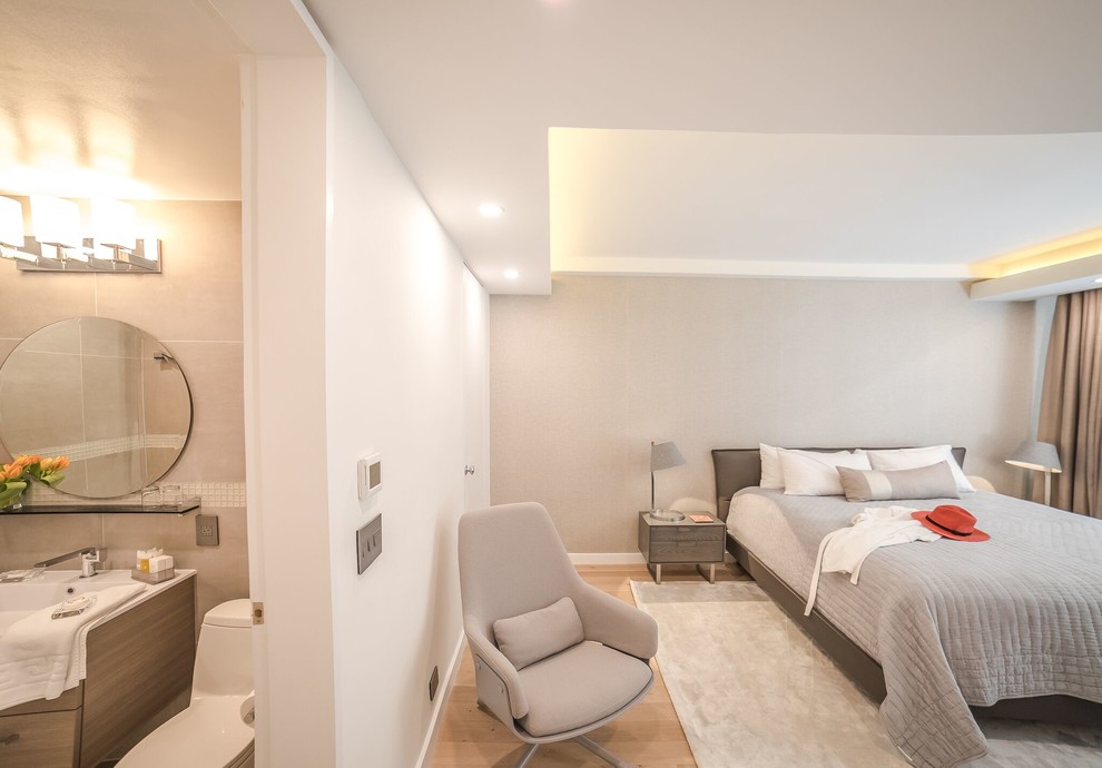 Imagen de dormitorio principal moderno de tamaño medio sin chimenea con paredes grises, suelo de madera clara y suelo beige