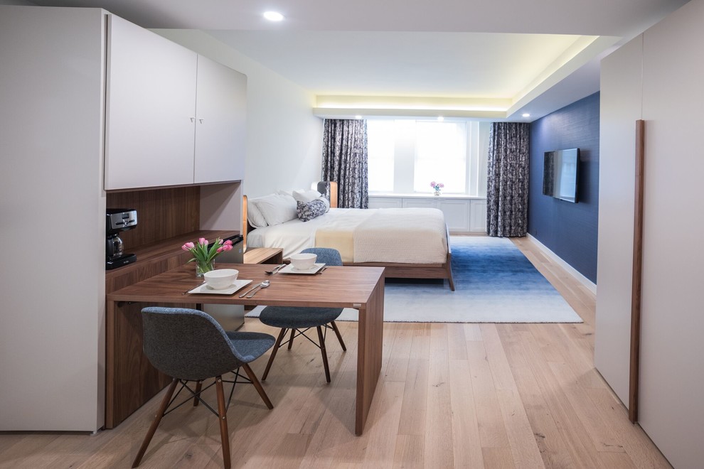 Idéer för att renovera ett mellanstort funkis gästrum, med blå väggar, ljust trägolv och beiget golv