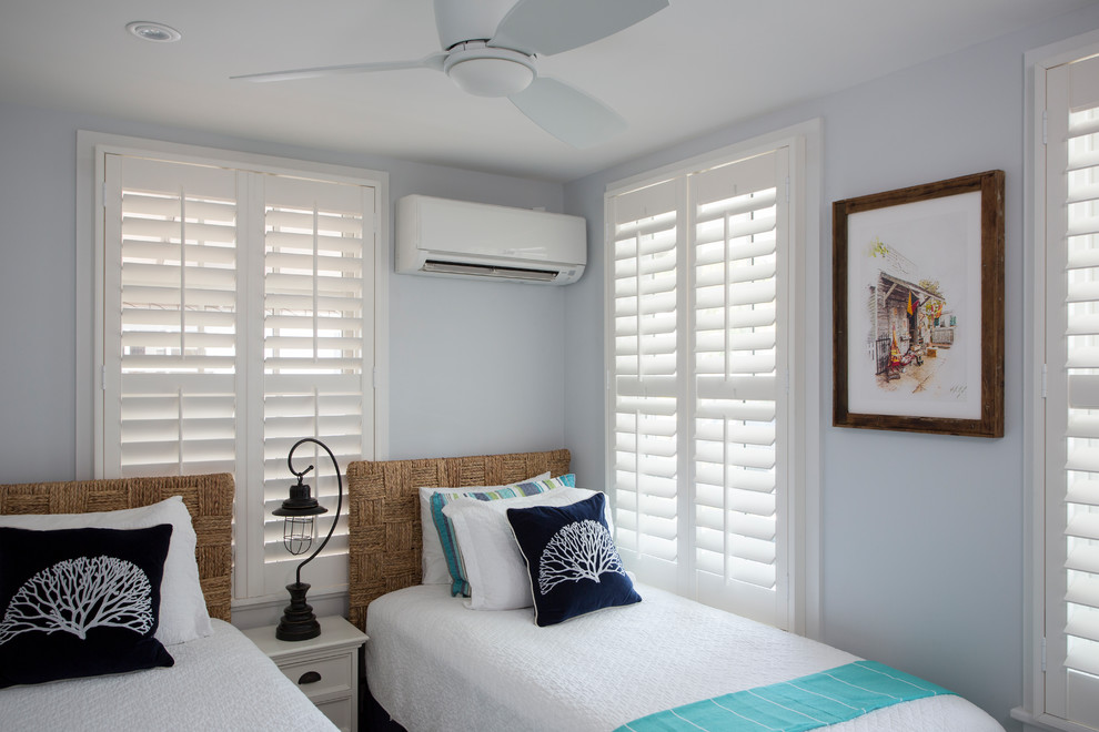 Bedroom - small coastal guest medium tone wood floor and brown floor bedroom idea with blue walls