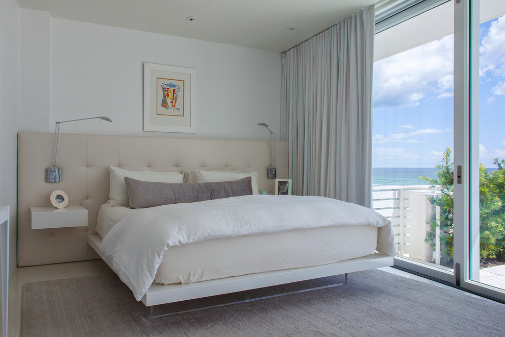 マイアミにある広いコンテンポラリースタイルのおしゃれな主寝室 (白い壁、コンクリートの床、暖炉なし)