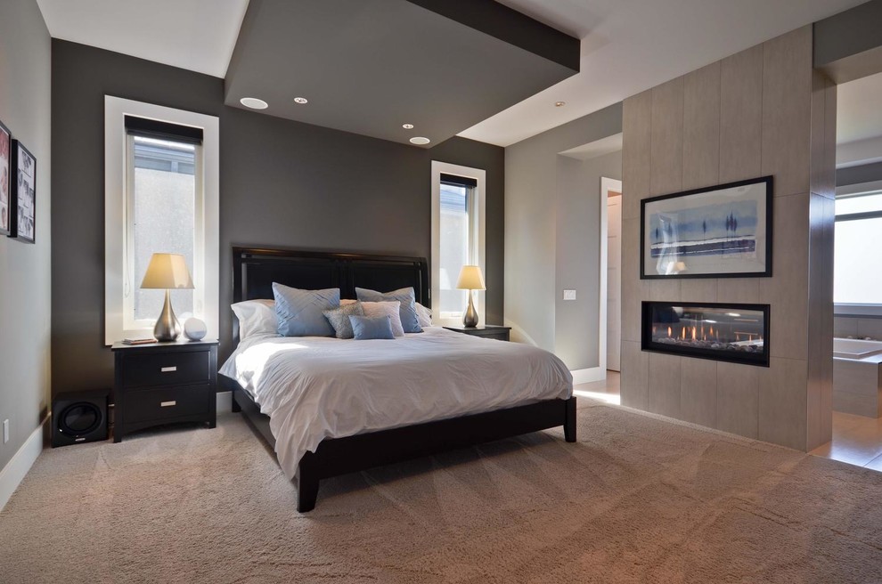Trendy master carpeted bedroom photo in Edmonton with a two-sided fireplace and a tile fireplace