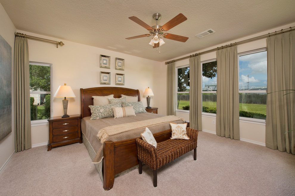 This is an example of a large traditional master and grey and cream bedroom in Houston with beige walls, carpet, no fireplace and beige floors.