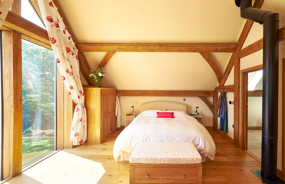 Immagine di una camera da letto stile rurale con pareti beige e pavimento in legno massello medio