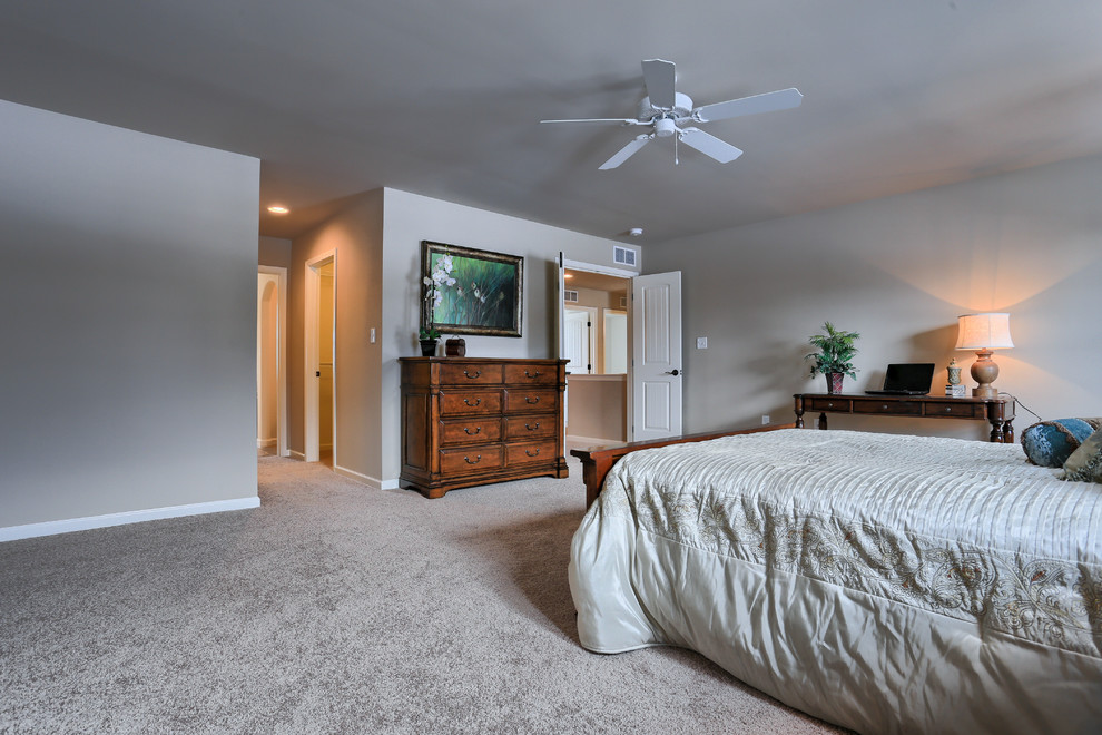 他の地域にある広いトラディショナルスタイルのおしゃれな主寝室 (茶色い壁、カーペット敷き) のインテリア