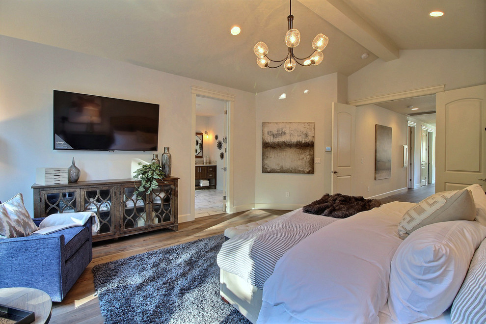 Ejemplo de dormitorio principal de estilo americano extra grande sin chimenea con paredes beige, suelo de madera en tonos medios y suelo marrón