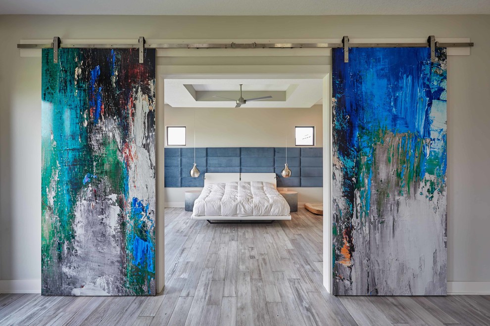 Ispirazione per una camera da letto contemporanea con pareti beige, parquet chiaro e pavimento grigio