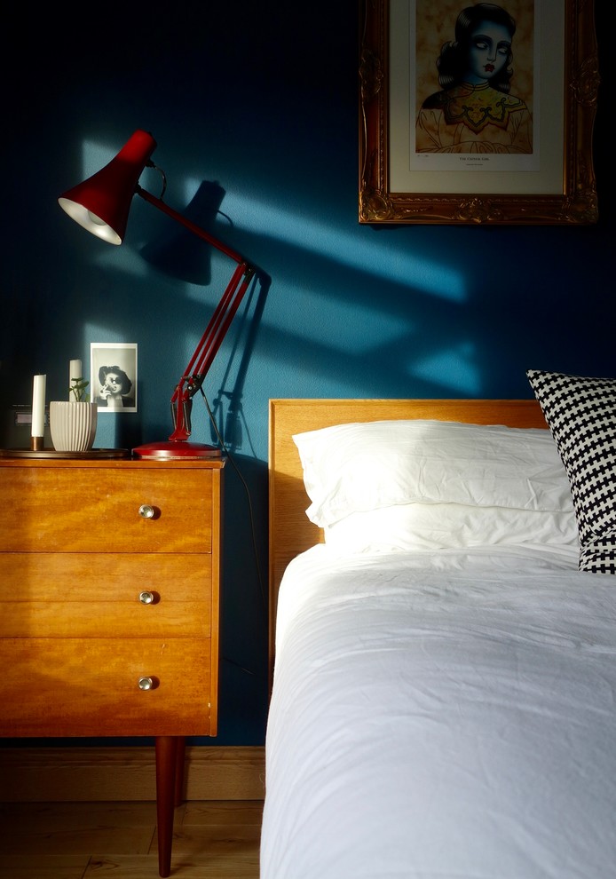 他の地域にある中くらいなミッドセンチュリースタイルのおしゃれな主寝室 (青い壁、淡色無垢フローリング)
