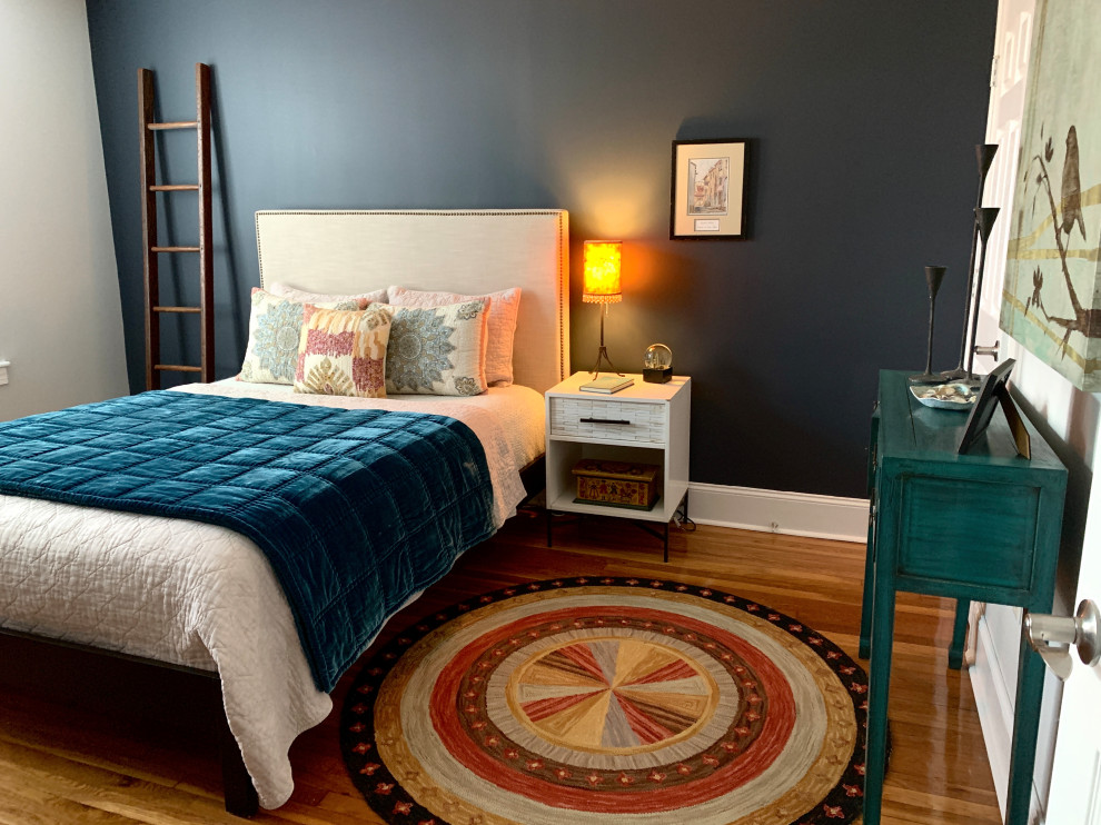 Modelo de dormitorio tradicional renovado de tamaño medio con paredes grises, suelo de madera oscura y suelo marrón