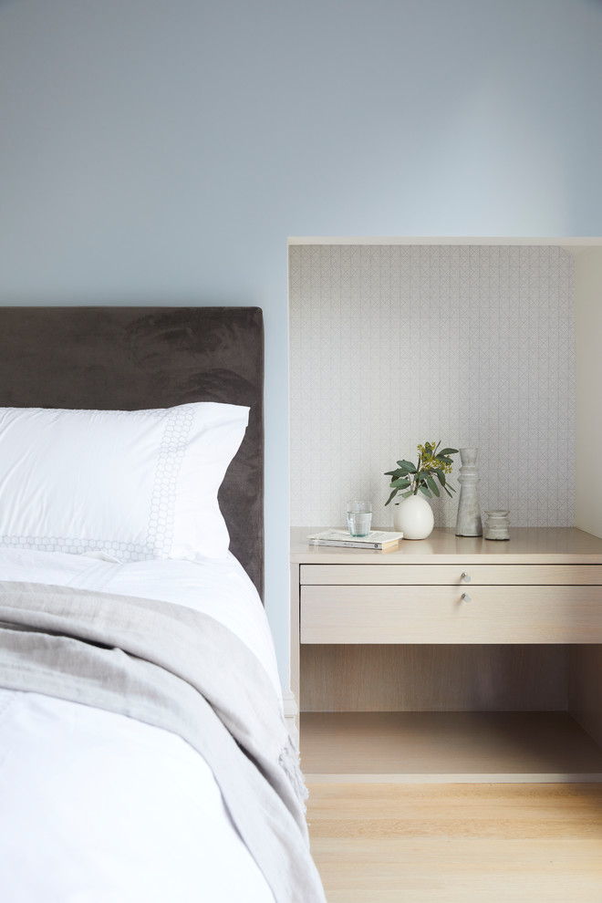 Ejemplo de dormitorio actual con paredes azules, suelo de madera clara y suelo beige