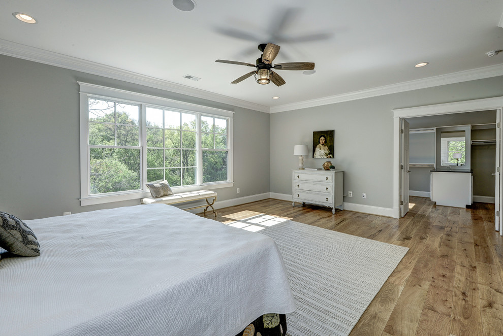 Large modern master bedroom in DC Metro with grey walls and light hardwood flooring.