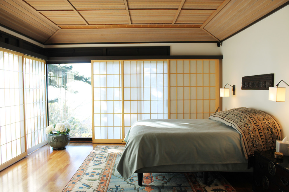 Idée de décoration pour une grande chambre parentale asiatique avec un mur beige, parquet clair, aucune cheminée et un sol marron.
