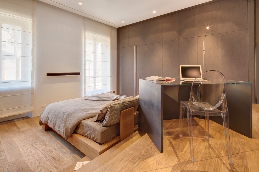 Cette photo montre une chambre parentale moderne avec un mur marron et parquet clair.