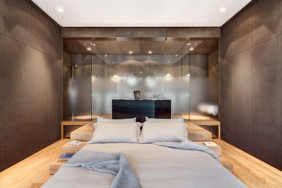 Ejemplo de dormitorio principal contemporáneo con paredes marrones y suelo de madera clara