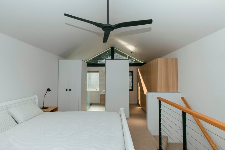 Diseño de dormitorio tipo loft contemporáneo pequeño sin chimenea con paredes blancas, moqueta y marco de chimenea de ladrillo
