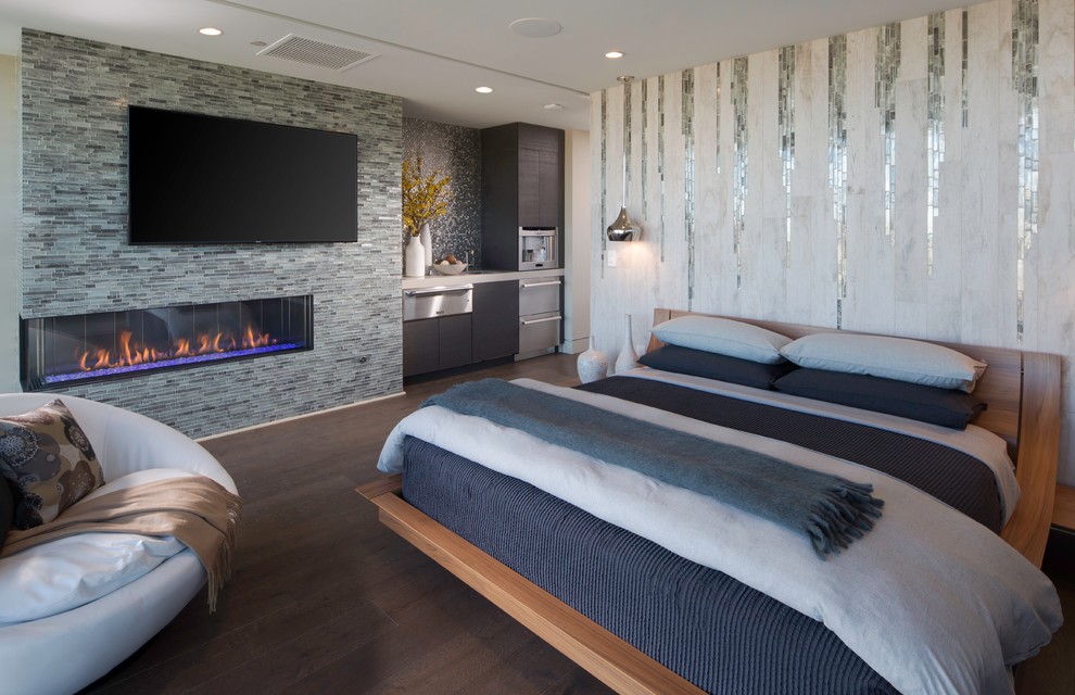 Ejemplo de dormitorio principal y televisión contemporáneo grande con paredes multicolor, suelo de madera oscura, chimenea lineal y marco de chimenea de baldosas y/o azulejos