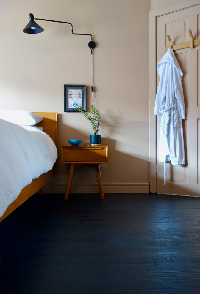 他の地域にある中くらいなミッドセンチュリースタイルのおしゃれな主寝室 (ラミネートの床、黒い床)