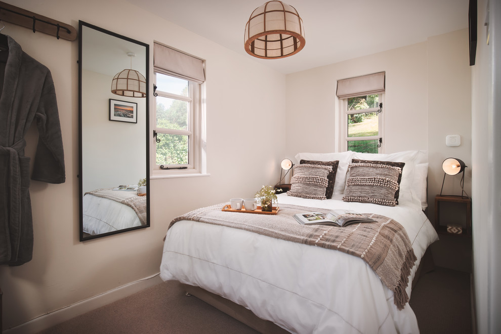 Esempio di una piccola camera degli ospiti country con pareti beige, moquette e pavimento beige