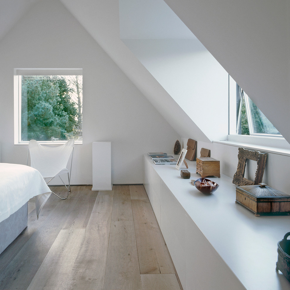 Diseño de habitación de invitados actual de tamaño medio con paredes blancas y suelo de madera clara