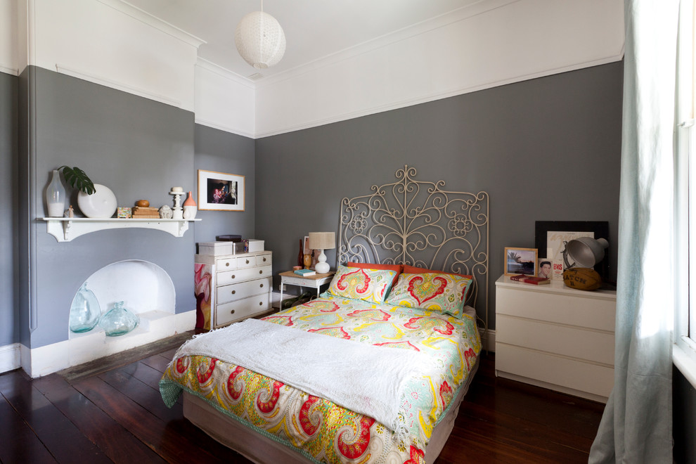 Bild på ett litet eklektiskt sovrum, med grå väggar och mörkt trägolv