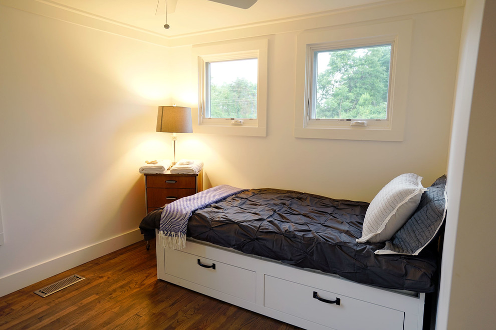 This is an example of a medium sized contemporary guest bedroom in Other with white walls and dark hardwood flooring.