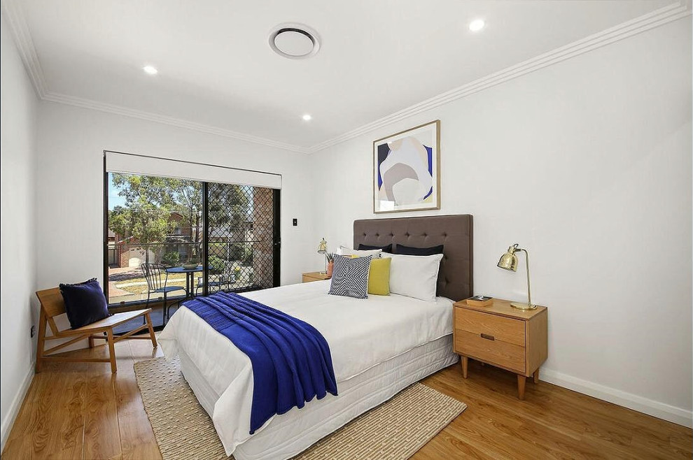 Mittelgroßes Modernes Gästezimmer mit grauer Wandfarbe, braunem Holzboden und braunem Boden in Sydney