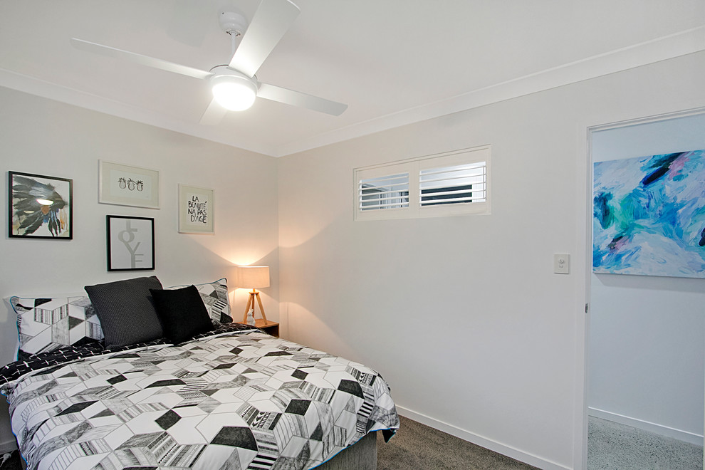 ゴールドコーストにあるコンテンポラリースタイルのおしゃれな客用寝室 (白い壁、カーペット敷き)