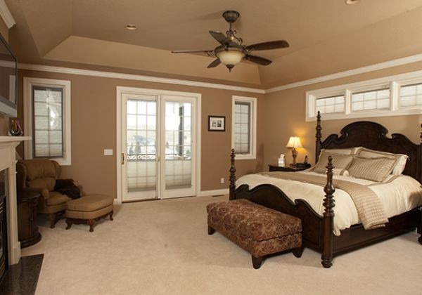 Medium sized traditional master bedroom in Other with beige walls, carpet, a standard fireplace, a wooden fireplace surround and beige floors.