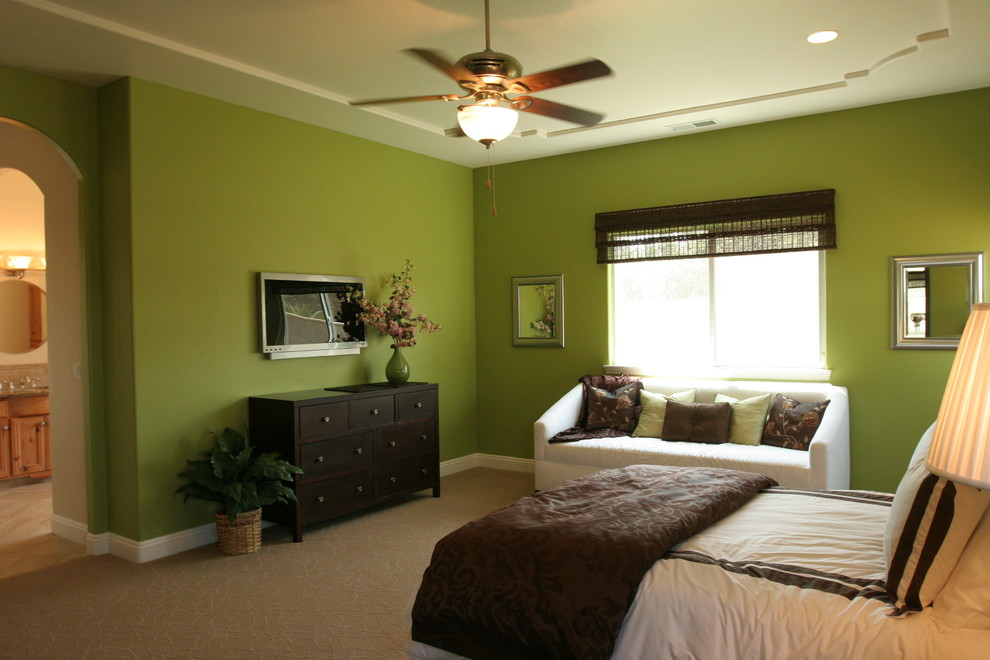 Foto på ett stort medelhavsstil huvudsovrum, med gröna väggar och heltäckningsmatta
