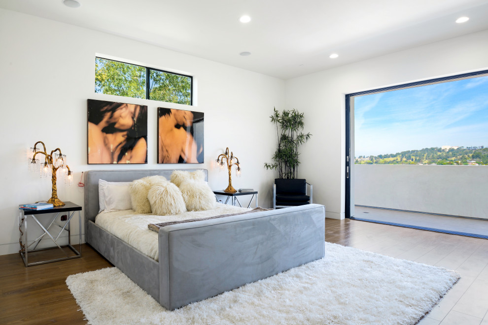 Imagen de dormitorio contemporáneo de tamaño medio con paredes blancas, suelo de madera clara, suelo beige, chimenea lineal y marco de chimenea de yeso