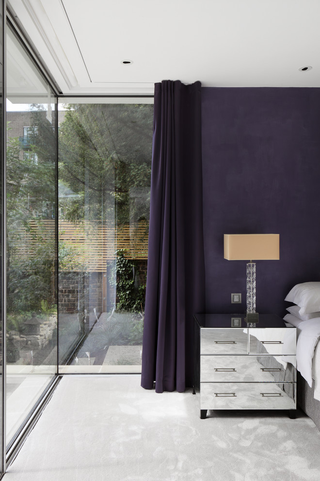 На фото: хозяйская спальня среднего размера в современном стиле с фиолетовыми стенами и ковровым покрытием без камина с