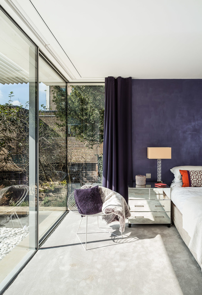 Inspiration for a contemporary bedroom in London with purple walls and carpet.