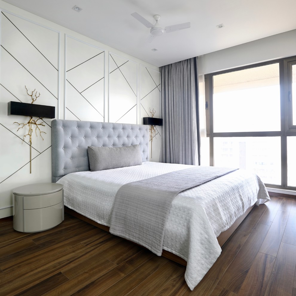 Exemple d'une chambre d'amis tendance avec un mur blanc, parquet foncé et un sol marron.