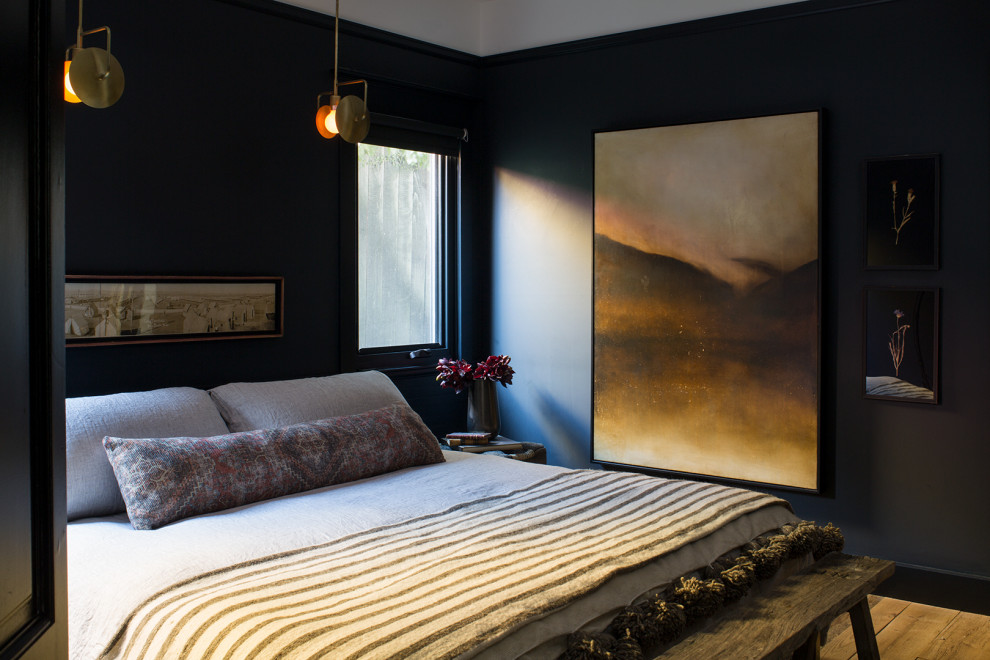 Mittelgroßes Modernes Gästezimmer ohne Kamin mit schwarzer Wandfarbe, hellem Holzboden und beigem Boden in Los Angeles