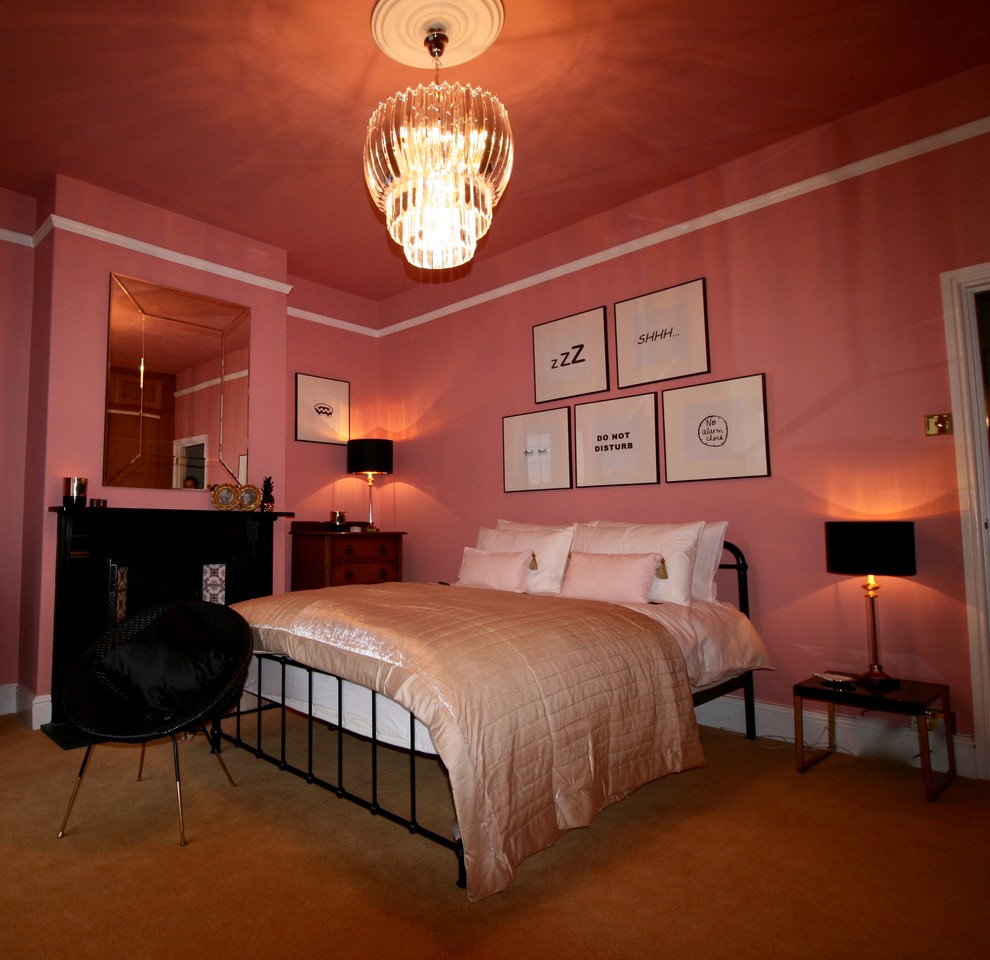 Пример оригинального дизайна: большая хозяйская спальня в стиле фьюжн с розовыми стенами, ковровым покрытием, стандартным камином и фасадом камина из дерева