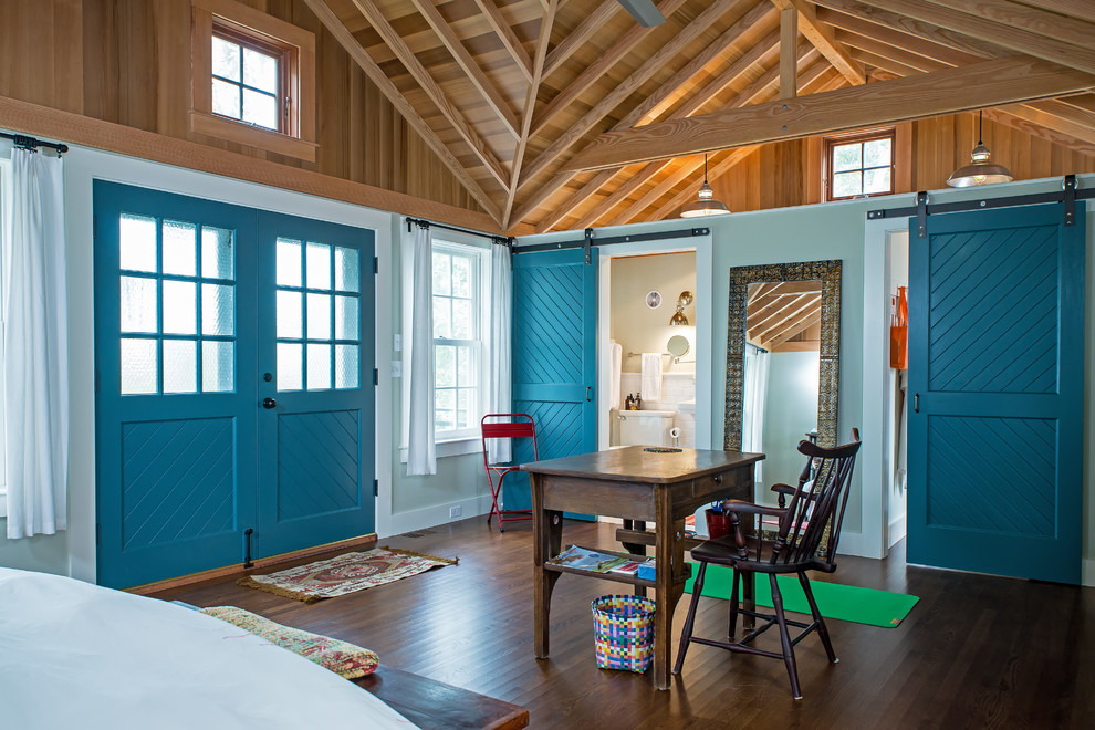 Diseño de dormitorio principal campestre grande con paredes azules, suelo de madera oscura y suelo marrón