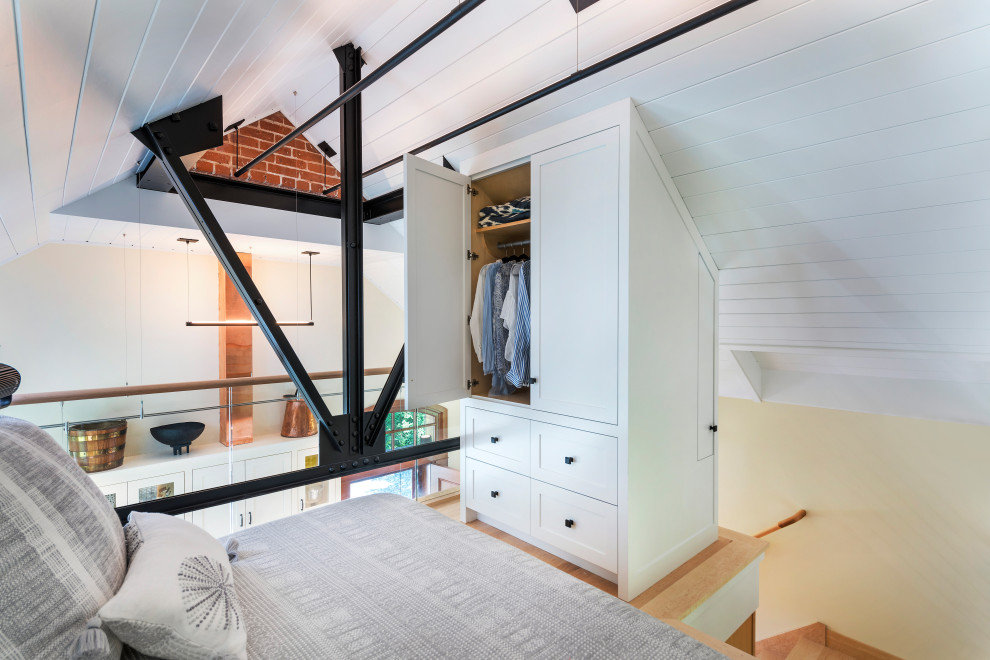 Imagen de habitación de invitados industrial pequeña con paredes blancas, suelo de madera clara y suelo beige