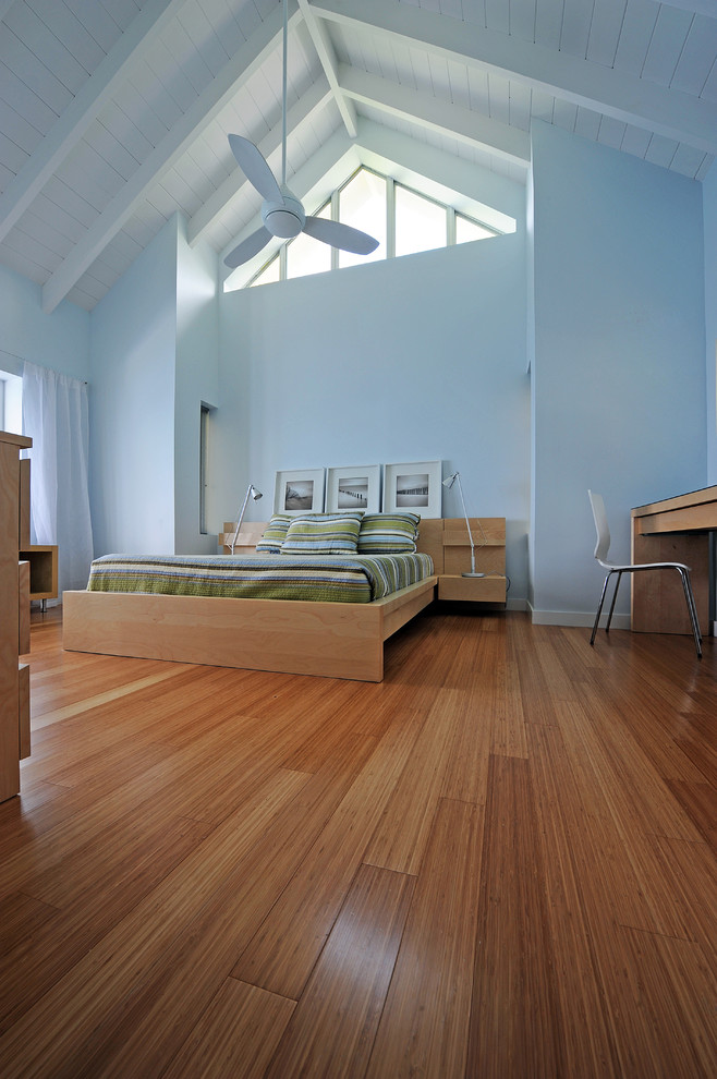 На фото: спальня в современном стиле с синими стенами, полом из бамбука и коричневым полом