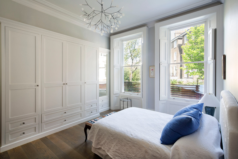 Design ideas for a traditional master bedroom in London with dark hardwood flooring and grey walls.